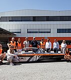 Studenci z zespołu aCentauri Solar Racing Team z ETH Zurich prezentują swój pojazd solarny w terminalu Air & Sea w Wolfurt – w towarzystwie przedstawicieli firmy Gebrüder Weiss.